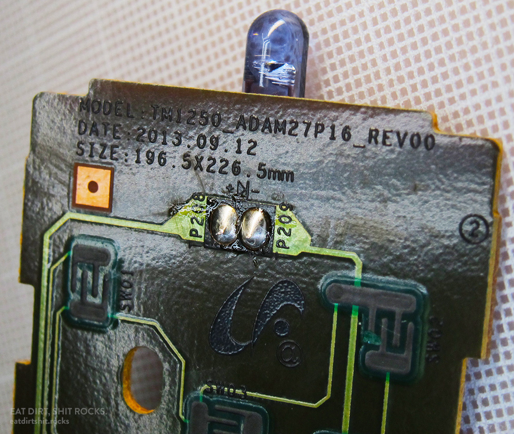 The business end of the PCB inside the TV remote, featuring its infrared LED and make and model information.